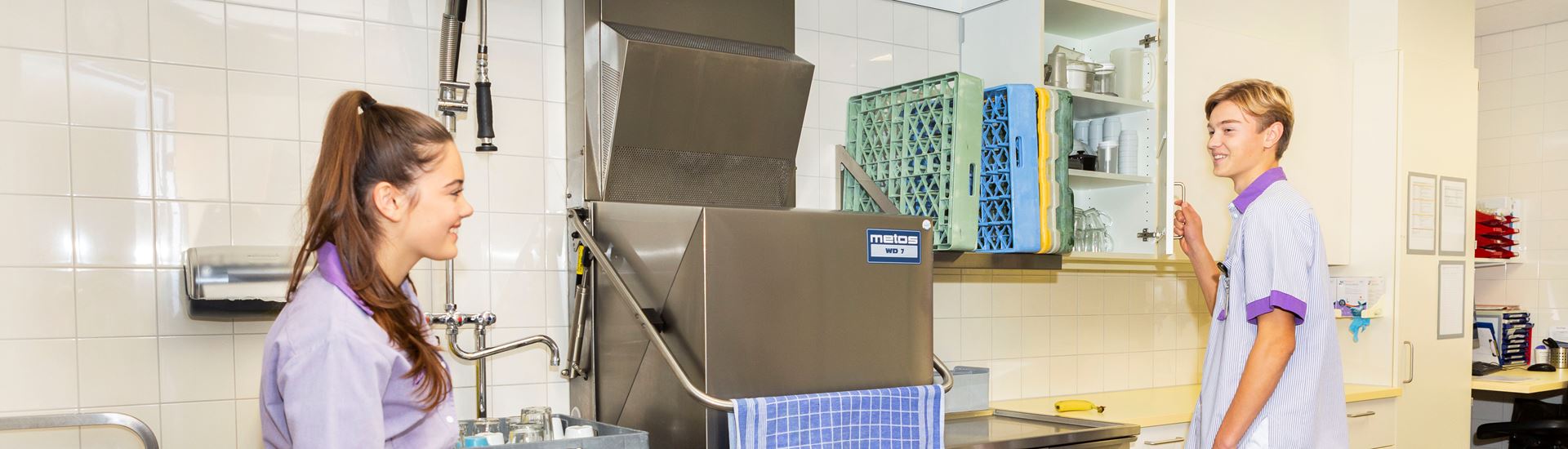 Service assistent en schoonmaker staan in de keuken van een verpleegafdeling Service assistent en schoonmaker staan in de keuken van een verpleegafdeling